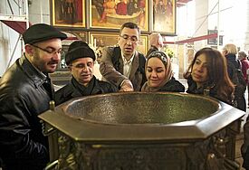 Eine Gruppe von Muslimen und Christen steht am Taufbecken in der Wittenberger Stadtkirche, der bevorzugten Predigtkirche von Martin Luther. (epd-Archiv, Symbolbild)