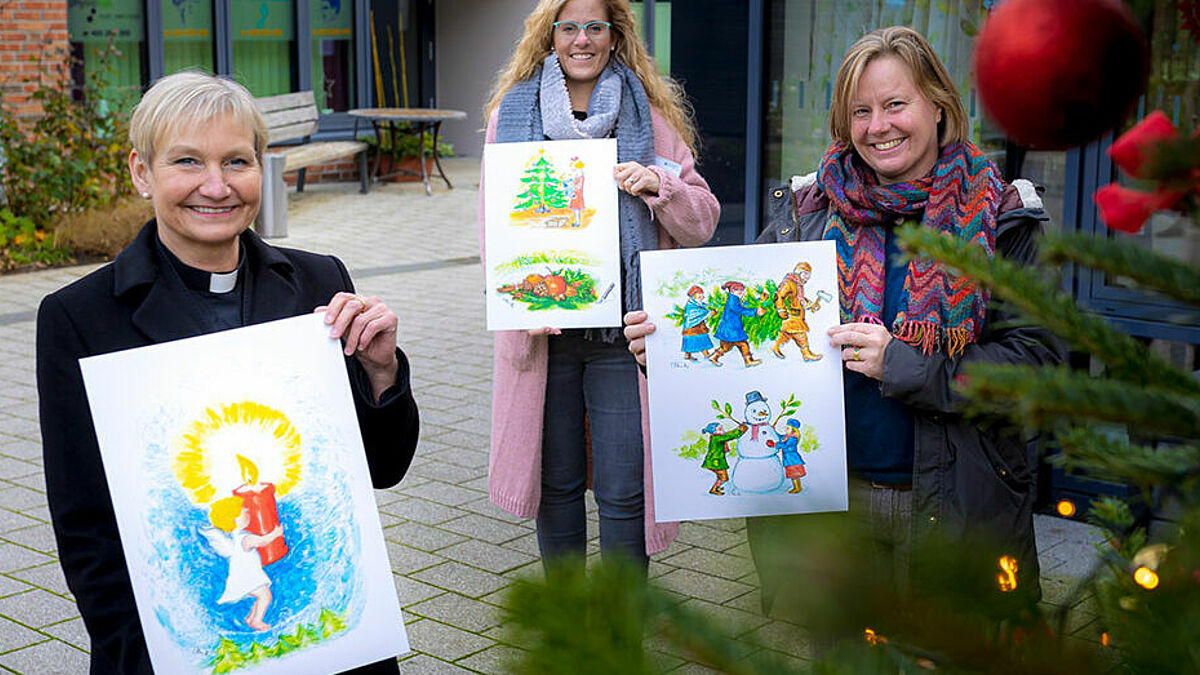 Fröhlich sind die Illustrationen von Künstlerin Inga Ortmann-Röpke (r.) aus Lübeck. Die Motive zum Thema "Kindheit und Weihnachten" gefielen auch der Hamburger Bischöfin Kirsten Fehrs (l.) und Heimleiterin Stefanie Heiland