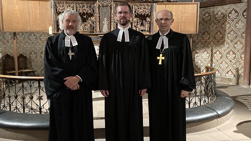 Propst Erich Fähling, Kirchenkreis Plön-Segeberg, und Bischof Magaard haben Pastor Moritz Christoph Müller in ihre Mitte genommen.