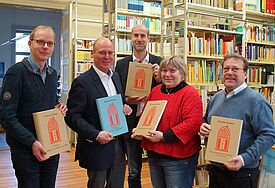 Strahlende Gesichter im pommerschen Kirchenkreisarchiv im Greifswalder Regionalzentrum: Rudolf Kabiersch (2. v. li.) und Dietmar Eifler (rechts) übergaben die druckfrischen Exemplare der transkribierten Kirchen- und Schulchroniken an Kirchenkreisarchivarin Jana Holzberg, Propst Tobias Sarx (Mitte) und Kirchenkreisarchivmitarbeiter Arvid Hansmann. 