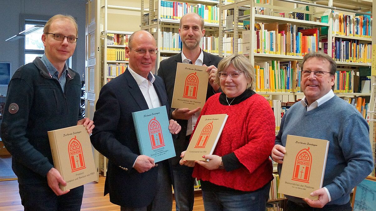 Strahlende Gesichter im pommerschen Kirchenkreisarchiv im Greifswalder Regionalzentrum: Rudolf Kabiersch (2. v. li.) und Dietmar Eifler (rechts) übergaben die druckfrischen Exemplare der transkribierten Kirchen- und Schulchroniken an Kirchenkreisarchivarin Jana Holzberg, Propst Tobias Sarx (Mitte) und Kirchenkreisarchivmitarbeiter Arvid Hansmann. 