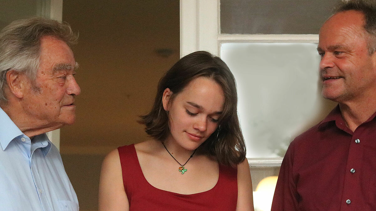 Drei Generationen Familie Jeremias: Prof. Jörg Jeremias, Camilla und Bischof Tilman Jeremias beim Betrachten alter Familienfotos (von links). Drei Generationen Familie Jeremias: Prof. Jörg Jeremias, Camilla und Bischof Tilman Jeremias beim Betrachten alter Familienfotos im Max Samuel Haus im Rahmen einer Veranstaltung.