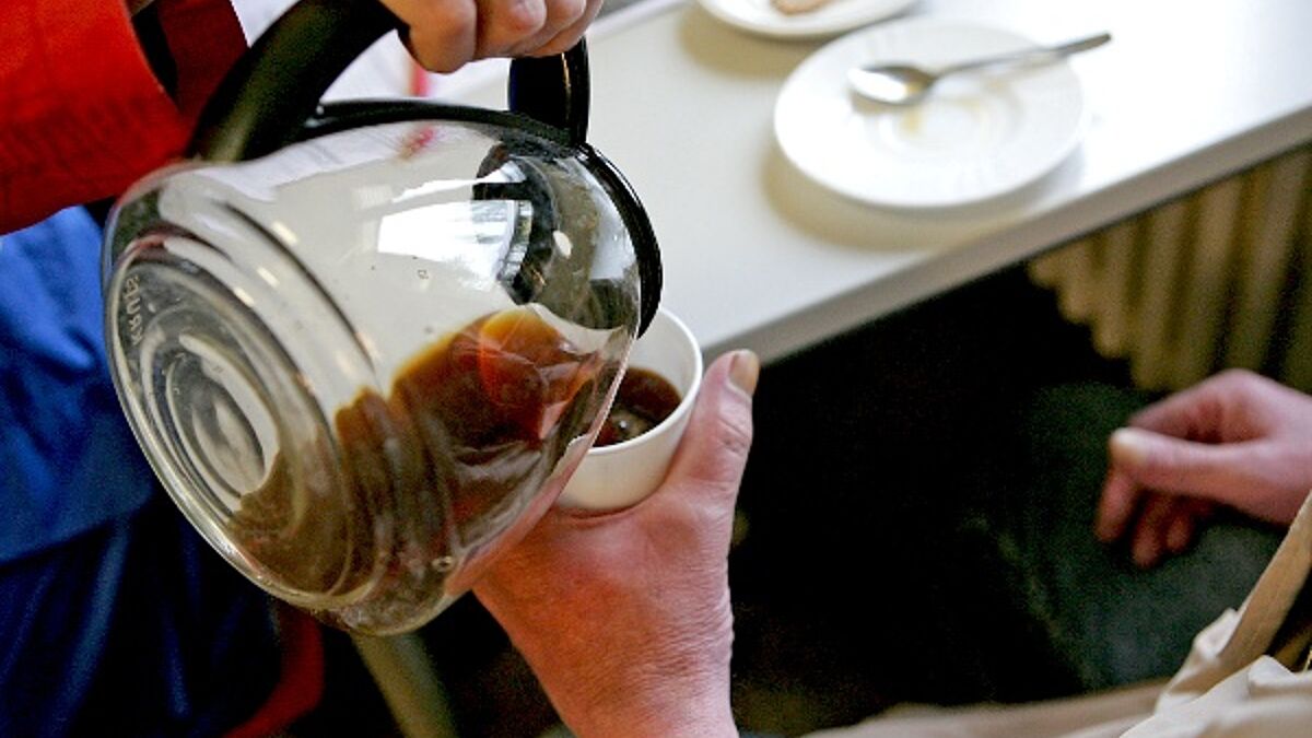 Ehrenämter gibt es in der Kirche viele - hier schenkt eine Mitarbeitern der Bahnhofsmission einem Gast Kaffee nach.