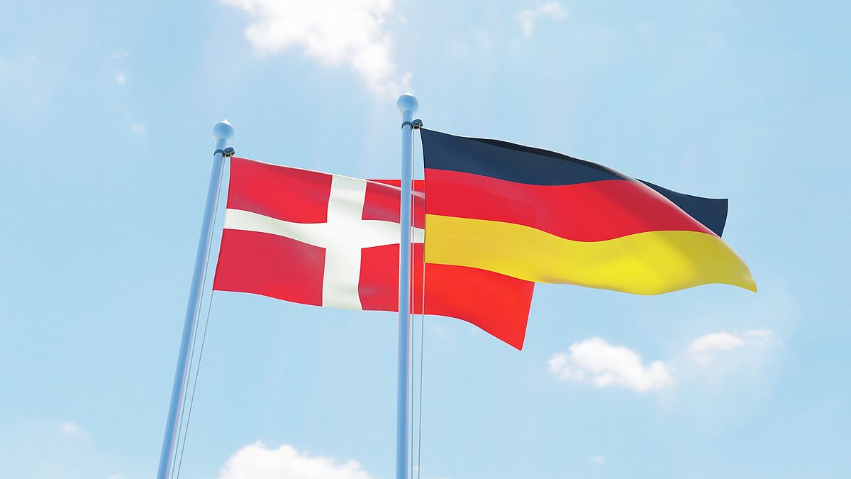 Die dänische und die deutsche Flagge wehen im Wind.