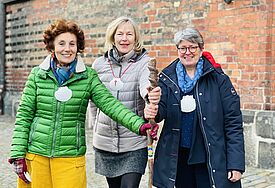 Belén Diaz-Amodia (li.) und Regina Musa (re.) mit Pastorin Kathrin Jedeck auf dem Kirchhof von St. Jakobi. Allein hier kreuzen drei Pilgerwege.