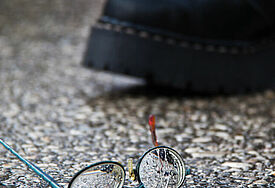Stiefel und zerbrochene Brille als Symbol für Rechte Gewalt 