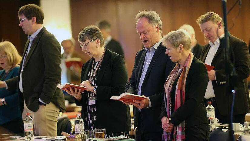 Die Mitglieder der Landessynode gedenken aller die unter dem Krieg leiden: Landesbischöfin Kühnbaum-Schmidt (zweite von links), Bischof Tilman Jeremias und Bischöfin Kirsten Fehrs (rechts). 