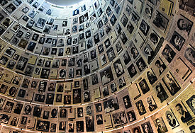 Eine große Halle mit schwarz-weiß-Fotografien von Menschen, die im Holocaust ums Leben kamen..