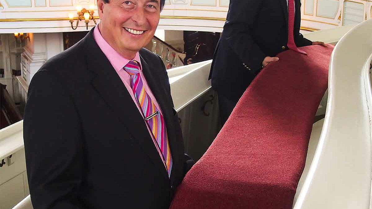 Dr. Heinz Wings, Vorstandsvorsitzender der Sparda-Bank Hamburg und Hauptpastor Alexander Röder rücken die neuen Sitzgelegenheiten im Michel zurecht