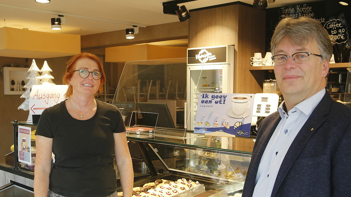 In Husum nimmt Doris Hansen von der gleichnamigen Bäckerei das Schild zur Aktion von Pastor Andreas Raabe entgegen. 