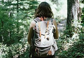 Frau mit Rucksack im Wald 