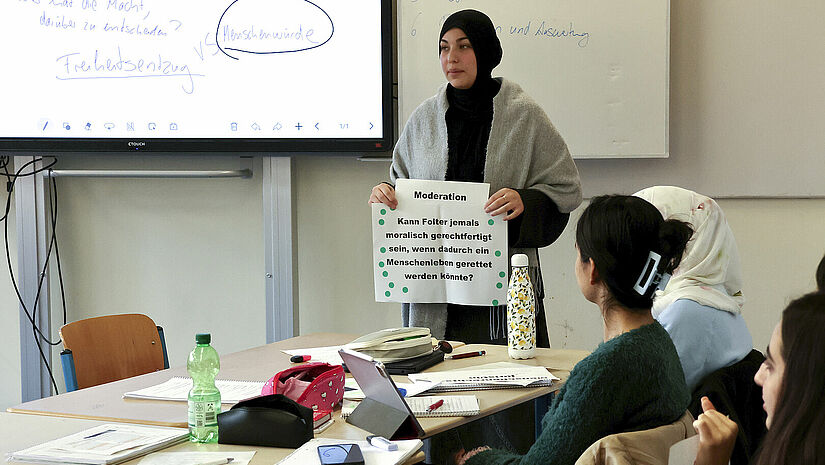 Eine Lehrerin zeigt ein Schaubild 