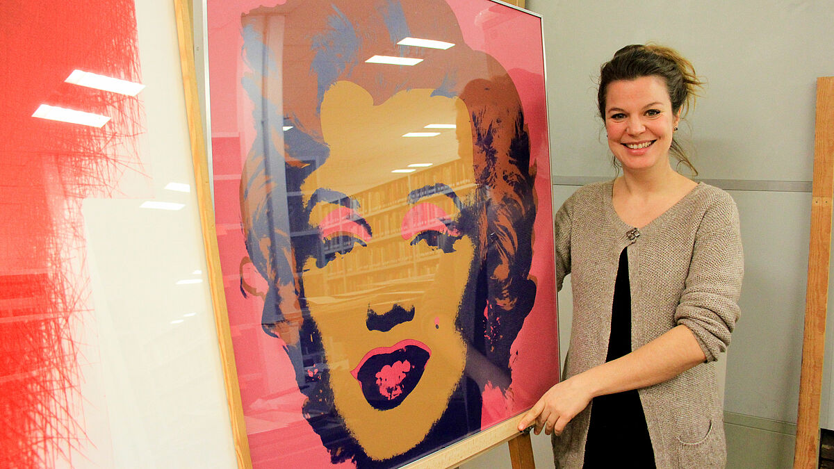 Luise Klafs, Studienleiterin von Kunst und Kirche in der Nordkirche, zeigt die "Marilyn" von Andy Warhol, links daneben steht das "Rote Kreuz" von Arnulf Rainer.