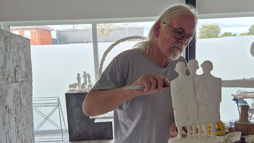 Ein Künstler areitet an einer Gruppe aus drei Figuren. Es sollen die Könige für eine Krippe werden.