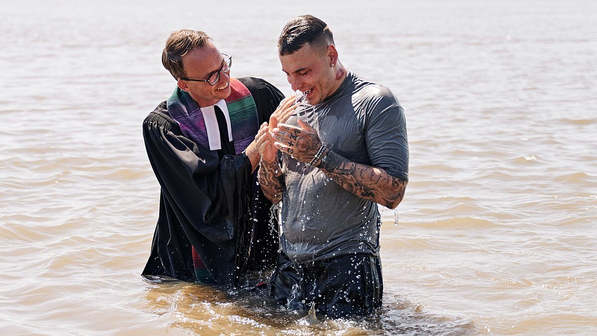 Pastor Fabio Fried in seinem Element - im Elbwasser mit einem Täufling.