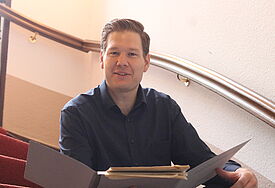 Richard Nölleke im denkmalgeschützten Treppenhaus Karl-Marx-Platz 16.