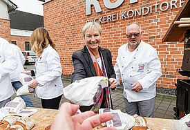Aktion Brot und Segen, Bischöfin Fehrs reicht ein Brot zum Martinstag über den Tresen