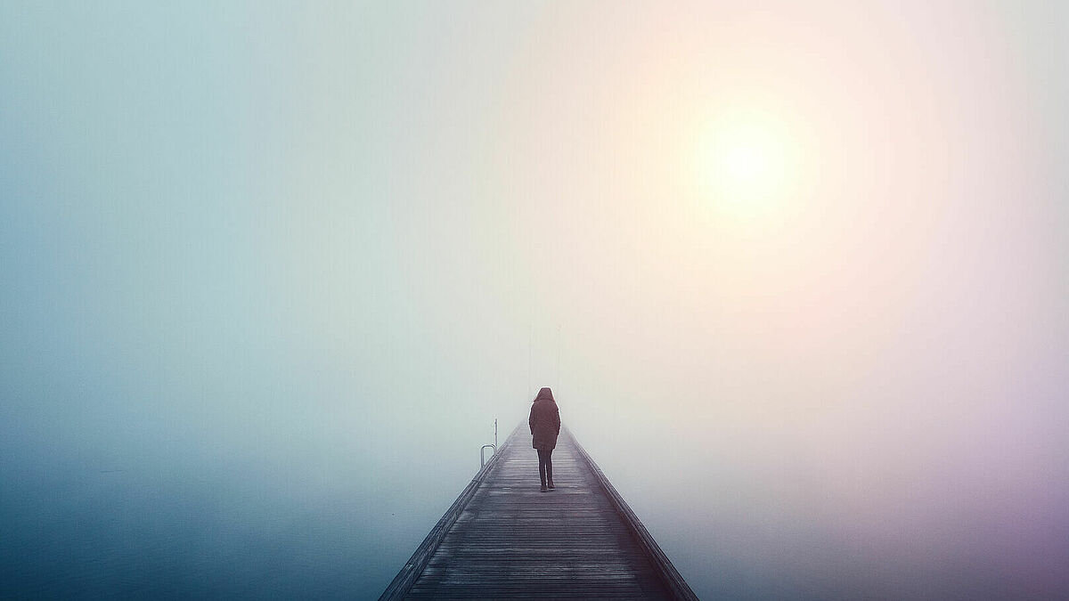 Mensch auf Brücke im Nebel