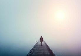 Mensch auf Brücke im Nebel