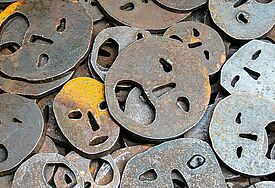 Metallplaketten: schreiende Gesichter als Symbol für das Leid, das die Opfer der Nationalsozialisten erfahren mussten