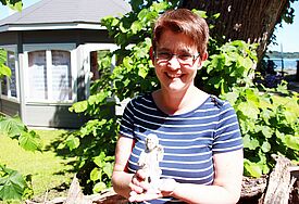Landesgartenschaupastorin Claudia Süssenbach im "Garten am frischen Wasser" in Eutin. Der Engel in ihren Händen wurde bei Bauarbeiten auf dem Gelände ausgegraben und hat nun einen Platz im Kirchengarten bekommen