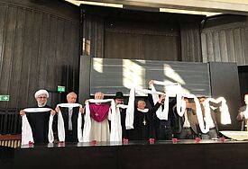Die Vertreter der Religiobsgemeinschaften beten gemeinsam für den Frieden in der Universität Hamburg.