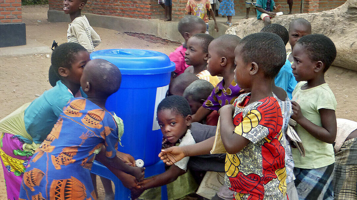 Kindergarten- und Schulkinder der Mkundi-Schule in der Region Dedza, Malawi, waschen sich im Rahmen eines Hygiene- und Schulspeisungsprogramms der Welthungerhilfe vor dem Essen und nach dem Toilettenbesuch die Hände (epd-Archiv 2017).