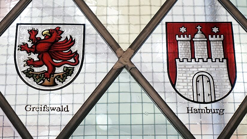 In Rauten sind die Wappen von Greifswald und Hamburg zu sehen