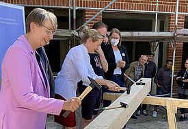 Landesbischöfin Kristina Kühnbaum-Schmidt und Rektorin Anne Gidion beim Einschlagen der Nägel