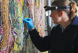 Anja Brigitta Haase reinigt die Glaspartikel des Altarbildes von Oskar Kokoschka.