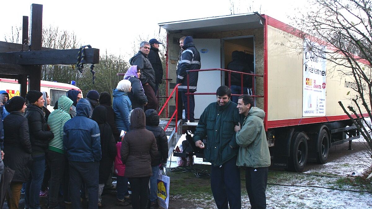 Mobile Kleiderkammer in der Schnackenburgallee gibt Winterkleidung und auch Süßes an Flüchtlinge weiter