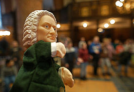 Eine Handpuppe, die den Musiker Bach darstellt. 
