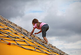 Ein Kind klettert auf einem Spielplatz