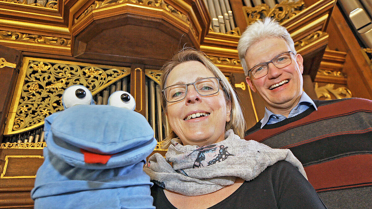 Anne-Katrin und Manuel Gera aus Hamburg mit Orgelwurm Willibald vor der historischen Bielfeldt-Orgel in der St.-Wilhadi-Kirche im niedersächsichem Stade
