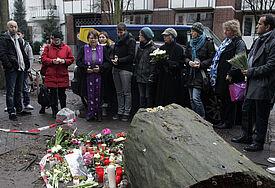 Flüchtlingspastorin Fanny Dethloff (Mitte) machte sich am Freitagmorgen (7.2.2014) selbst ein Bild an der Unglücksstelle in der Eimsbütteler Straße, wo bei einem Brand in einer Unterkunft für Flüchtlinge und Asylbewerber drei Menschen ums Leben kamen.