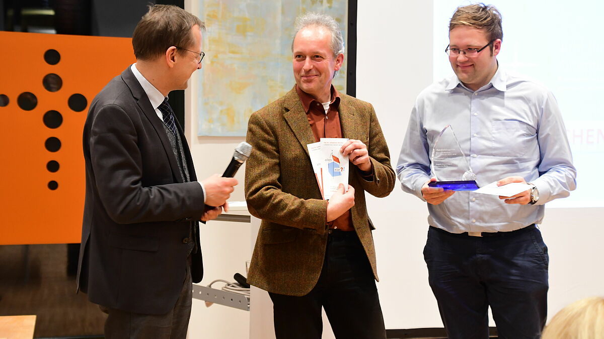 Michael Stahl (l.), Leiter des Amts für Öffentlichkeitsdienst, übergibt den Preis in der Kategorie Kommunikation an Pastor Albrecht Martins und Niels Sönnichsen aus der Kirchengemeinde Kücknitz.