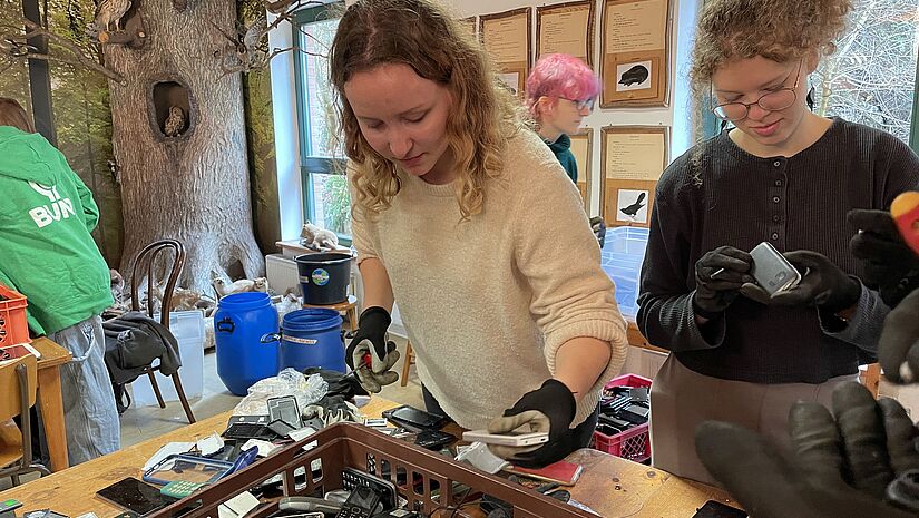 Handysortierparty Hannah und Anna sortieren Foto Pohl Zwei junge Frauen mit kaputten Handys