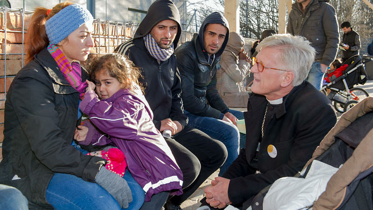 Der Ratsvorsitzende der Evangelischen Kirche in Deutschland (EKD), Heinrich Bedford-Strohm, spricht in einer Münchner Erstaufnahmeeinrichtung für Flüchtlinge mit syrischen Asylbewerbern (Archiv)
