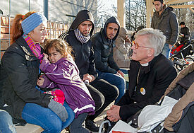 Der Ratsvorsitzende der Evangelischen Kirche in Deutschland (EKD), Heinrich Bedford-Strohm, spricht in einer Münchner Erstaufnahmeeinrichtung für Flüchtlinge mit syrischen Asylbewerbern (Archiv)