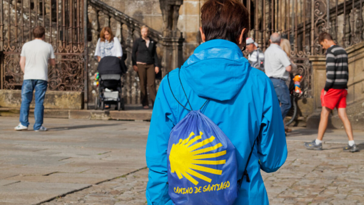 Eine Pilgerin am Ziel in Santiago de Compostela vor der Kathedrale des Heiligen Jakob.