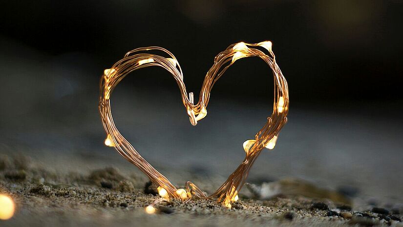 Ein Herz aus Drähten im Sand 