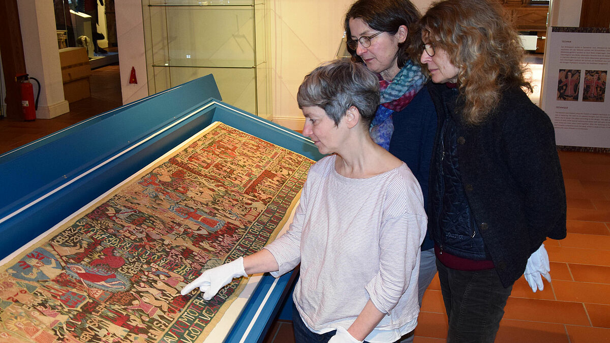Die Restauratorinnen Salwa-Victoria Joram (l.) und Christine Binroth vom Museum Europäischer Kulturen - Preußischer Kulturbesitz Berlin halfen Dr. Jutta Müller (Mitte) beim Aufbau der Ausstellung im Dithmarscher Landesmuseum.
