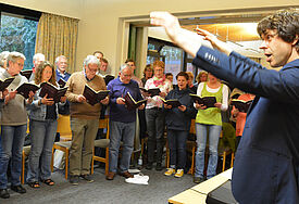 Kantor Peter Heeren probt mit seinen Sängern