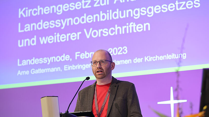 Arne Gattermann stellt die Gesetzesänderung zur Bildung der Landessynode vor, mit der die zukünftige paritätische Besetzung gewährleistet werden soll.