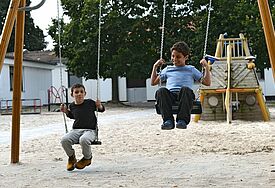 Syrische Flüchtlingskinder schaukeln auf einem Spielplatz im Grenzdurchgangslager Friedland in Niedersachsen (Archiv).