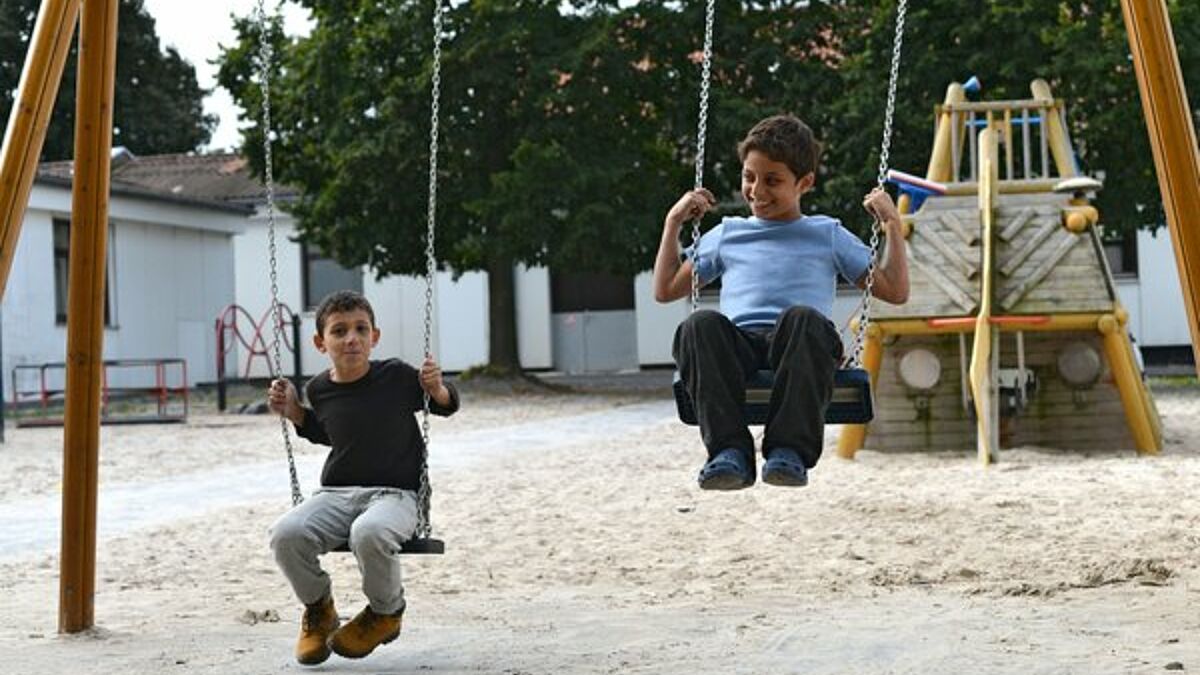 Syrische Flüchtlingskinder schaukeln auf einem Spielplatz im Grenzdurchgangslager Friedland in Niedersachsen (Archiv).