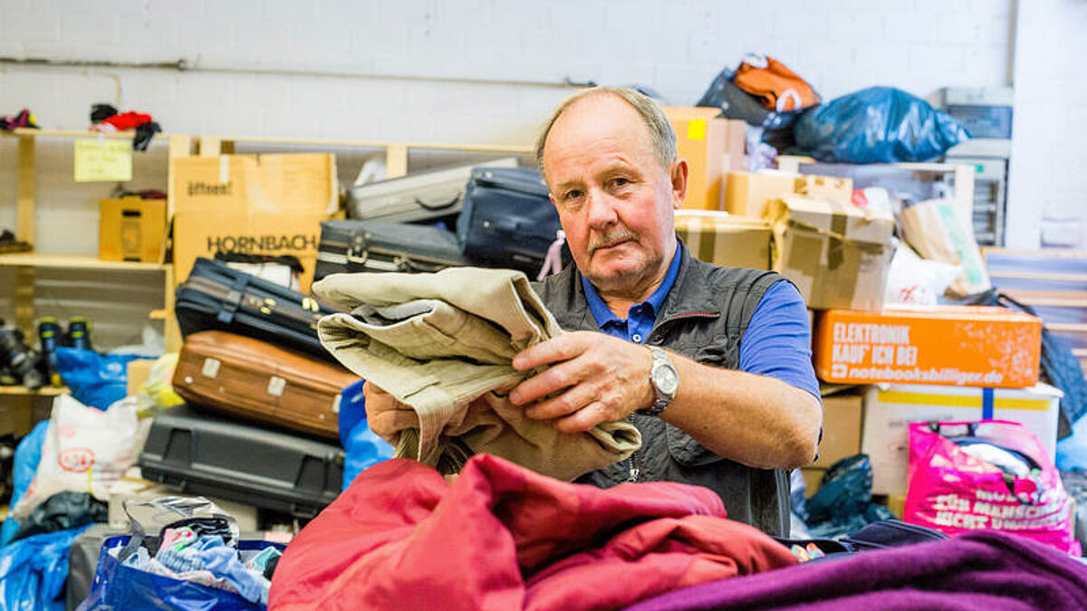 Ein ehrenamtlicher Helfer sortiert Kleidung in einer Annahmestelle für Sachspenden für Flüchtlinge (Symbolbild)