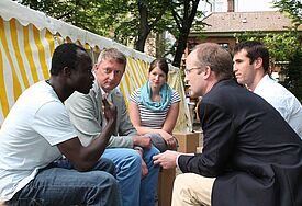 Andreas A. (li) ist einer der Sprecher der Fluechtlings-Gruppe "Lampedusa in Hamburg". Er sprach im Juni bereits mit dem amerikanischen Vize-Generalkonsul Robert Stevens (re). Mit dabei: Pastor Sieghard Wilm und Constanze Funck