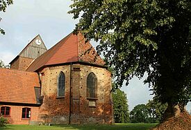 Backsteinkirche umgeben von Bäumen