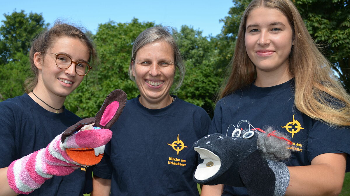 Sie sorgen für Programm am Strand: Teamerin Sophie Kleinlein (v.l.), Pastorin Brigitte Gottuk und Teamerin Chiara Anders. 

